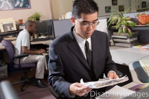 Young adult with a hidden disability files papers in an office